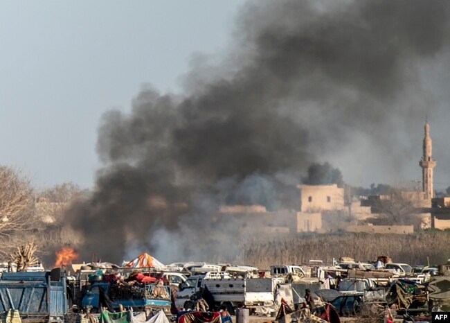 Smoke rises from a makeshift camp for Islamic State members and their families in the town of Baghuz, in the eastern Syrian province of Deir el-Zour, March 9, 2019.