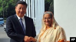 资料照片: 2016年10月14日，孟加拉国总理谢赫·哈西娜在孟加拉国达卡与中国国家主席习近平握手