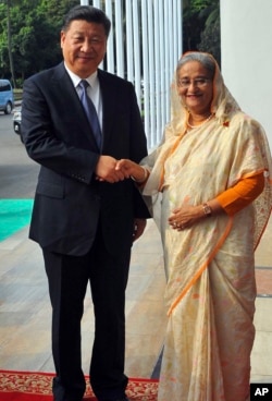 FILE - Bangladesh Prime Minister Sheikh Hasina is pictured with Chinese President Xi Jinping in Dhaka, Bangladesh, Oct. 14, 2016. During Xi's visit, the two countries signed agreements calling for, among other things, billions of dollars of Chinese investment in infrastructure and energy projects.