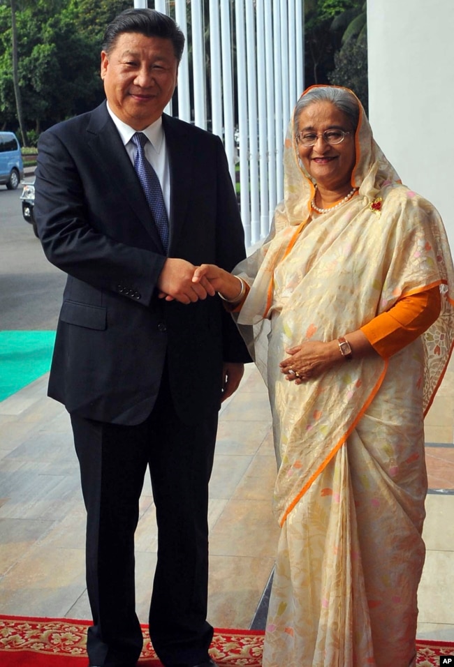 FILE - Bangladesh Prime Minister Sheikh Hasina is pictured with Chinese President Xi Jinping in Dhaka, Bangladesh, Oct. 14, 2016. During Xi's visit, the two countries signed agreements calling for, among other things, billions of dollars of Chinese investment in infrastructure and energy projects.