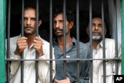 Pakistani villagers from right, Mohammad Akbar, Mohammad Ali and Liaquat Ali who are allegedly involved in the gang-rape of a woman stand behind bars at a local police station, July 7, 2005 in Chiniot, about 250 kilometers (150 miles) northwest of Multan, Pakistan.