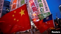 FILE - Members of a Taiwanese independence group march with flags around a group of pro-China supporters holding flags during a rally, in Taipei, May 14, 2016.