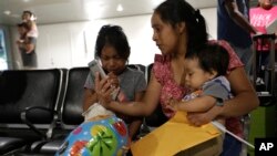 Buena Ventura Martin-Godinez, center, holds her son Pedro, right, as she is reunited with her daughter Janne, left, at Miami International Airport, July 1, 2018, in Miami, Florida. Martin crossed the border into the United States from Mexico in May with her son, fleeing violence in Guatemala. Her husband crossed two weeks later with their 7-year-old daughter Janne. All were caught by the Border Patrol, and were separated. Her daughter was released earlier from a child welfare agency in Michigan.