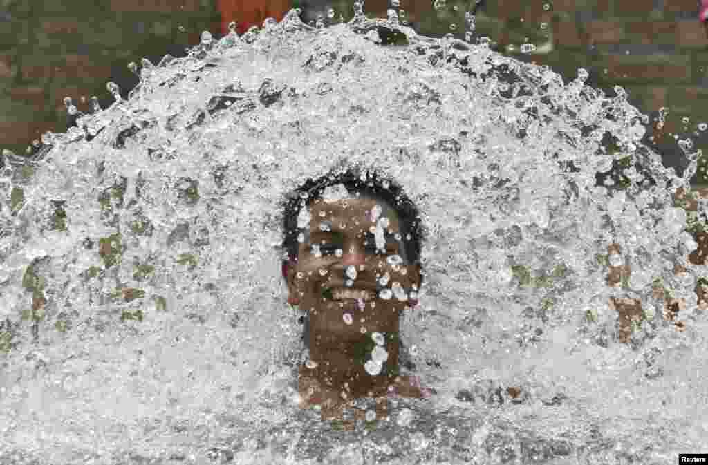 A boy cools himself in the waters of a tube well on a hot summer day at Manawala village on the outskirts of the northern Indian city of Amritsar.