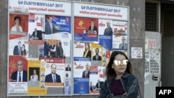 A woman walks past election posters on March 29, 2017 in Yerevan, ahead of April 2 parliamentary elections.