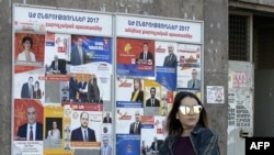 A woman walks past election posters on March 29, 2017 in Yerevan, ahead of April 2 parliamentary elections.