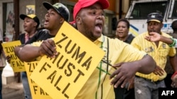 Supporters of the African National Congress President Cyril Ramaphosa hold placards and chant slogans during a demonstration against South African President Jacob Zuma outside ANC party headquarters in Johannesburg, South Africa, Feb. 5, 2018.