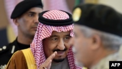 Le roi saoudien Salman ben Abdoulaziz salue les officiers militaires avant sa rencontre avec l'émir du Koweït à l’occasion de leur arrivée au 136e sommet du Conseil de coopération du Golfe (CCG) dans la capitale saoudienne, le 9 décembre 2015.