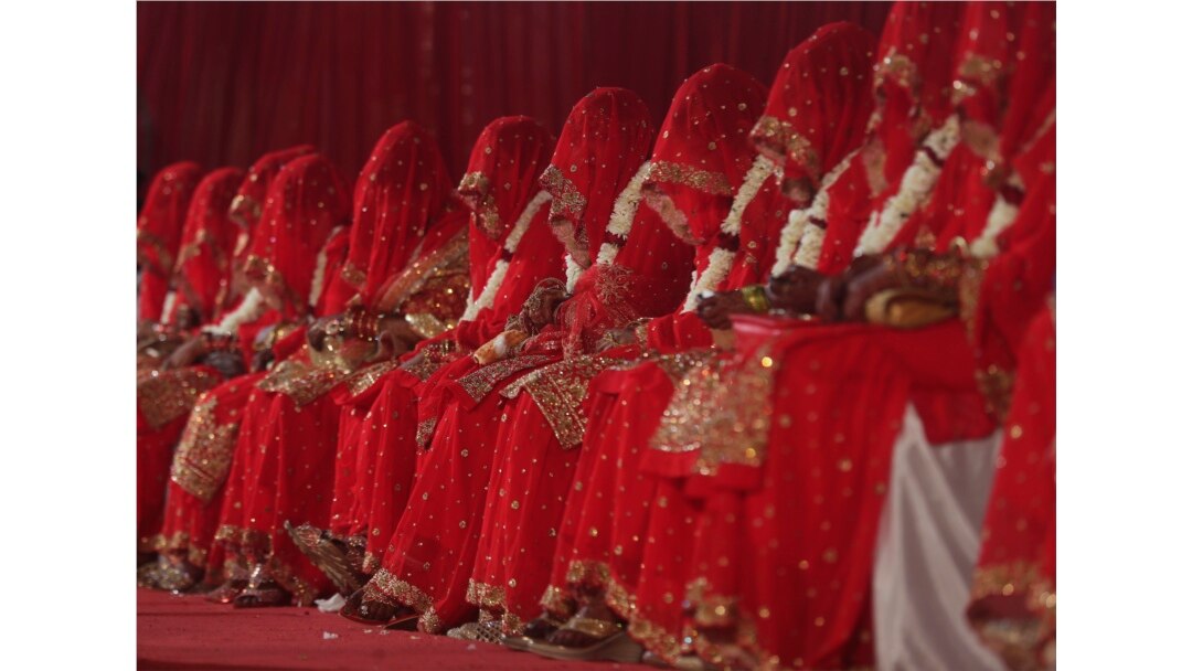 Pengantin Muslim India duduk selama pernikahan massal di mana enam puluh tiga pasangan menikah di Mumbai, India, Minggu, 14 Februari 2021. (Foto: AP)