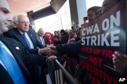 FILE - Democratic presidential candidate, Sen. Bernie Sanders, I-Vt., greets a CWA worker at a Verizon workers picket line in the Brooklyn borough of New York, April 13, 2016..