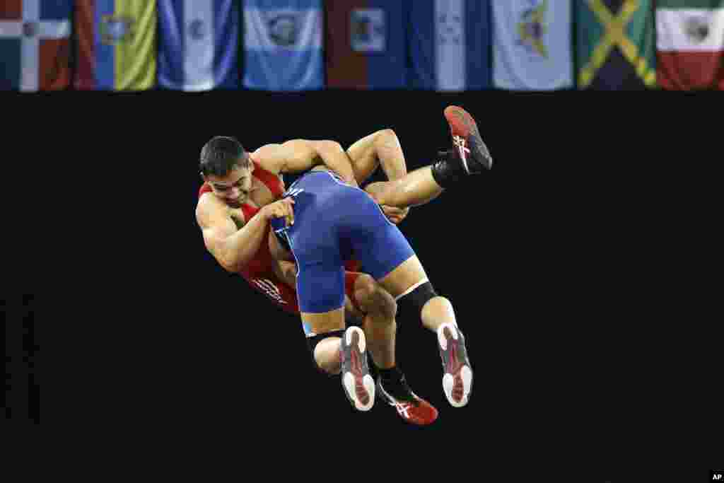 Johnathan Scott of Costa Rica (back) is dropped by Venezuela&#39;s Cristian Sacro during a men&#39;s freestyle 74 kg bronze medal wrestling match at the Pan Am Games in Mississauga, Ontario, Canada.