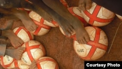 Children in Benin get a foot on their new soccer balls from Project Play Africa in 2010. (Courtesy Project Play Africa)