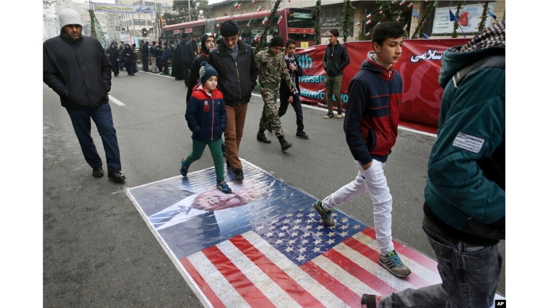 Iranians march on a portrait of U.S. President Donald Trump and the picture of U.S. flag in an annual rally commemorating the anniversary of the 1979 Islamic revolution, which toppled the late pro-U.S. Shah, Mohammad Reza Pahlavi, in Tehran, Iran, Feb. 10