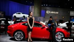 A man cleans a Jaguar at the 2013 Los Angeles Auto Show.