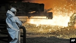 FILE - In this April 27, 2018 photo a steel worker watches the hot metal at the Thyssenkrupp steel factory in Duisburg, Germany. 