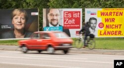 Election posters showing German Chancellor Angela Merkel, CDU, social democrat challenger Martin Schulz, SPD, center, and Free Democratic Party, FDP, federal chairman Christian Lindner, right, stand at a street in Erfurt, central Germany, Sept. 15, 2017.