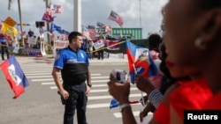 警方在佛罗里达海湖庄园附近把反对和支持川普总统的示威者分开。（2018年1月15日）