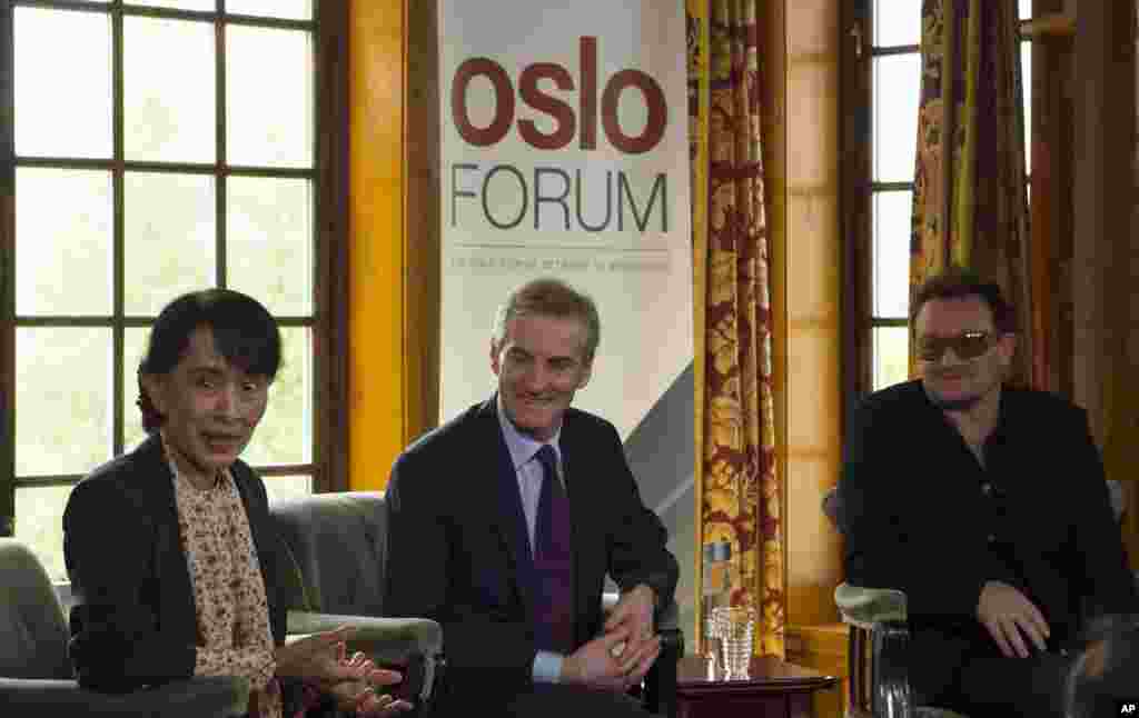 Dari kiri, Aung San Suu Kyi, Menteri Luar Negeri Norwegia Jonas Gahr Stoere dan penyanyi Irlandia dan aktivis Bono berbicara kepada media setelah menghadiri konferensi di Forum Oslo, Senin (18/6).