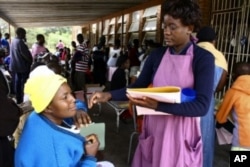 A MSF worker takes details from patients at a clinic in southern Zimbabwe