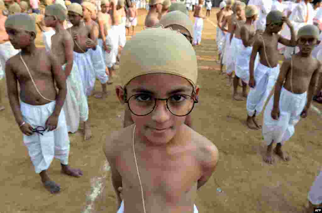 Anak-anak India berpakaian seperti Mahatma Gandhi mengantri untuk tampil di sebuah acara di Mumbai. Sekitar 1.000 anak-anak ikut dalam acara yang mempromosikan ideologi Gandhi untuk menyebarkan pesan hidup sederhana, mengurangi konsumsi dan limbah.