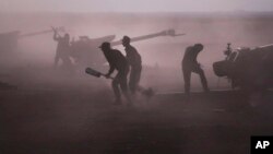 Syrian army personnel load howitzers near the village of Morek, Syria, Oct. 7, 2015.