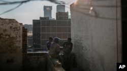 FILE - Malawian migrants sit on the rooftop of an abandoned building in downtown Johannesburg, South Africa, March 29, 2018. 