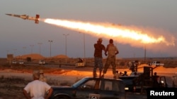Pejuang pasukan Libya yang bersekutu dengan pemerintahan yang didukung PBB menembakkan roket ke arah pejuang ISIS di Sirte, Libya (4/8). (Reuters/Goran Tomasevic)