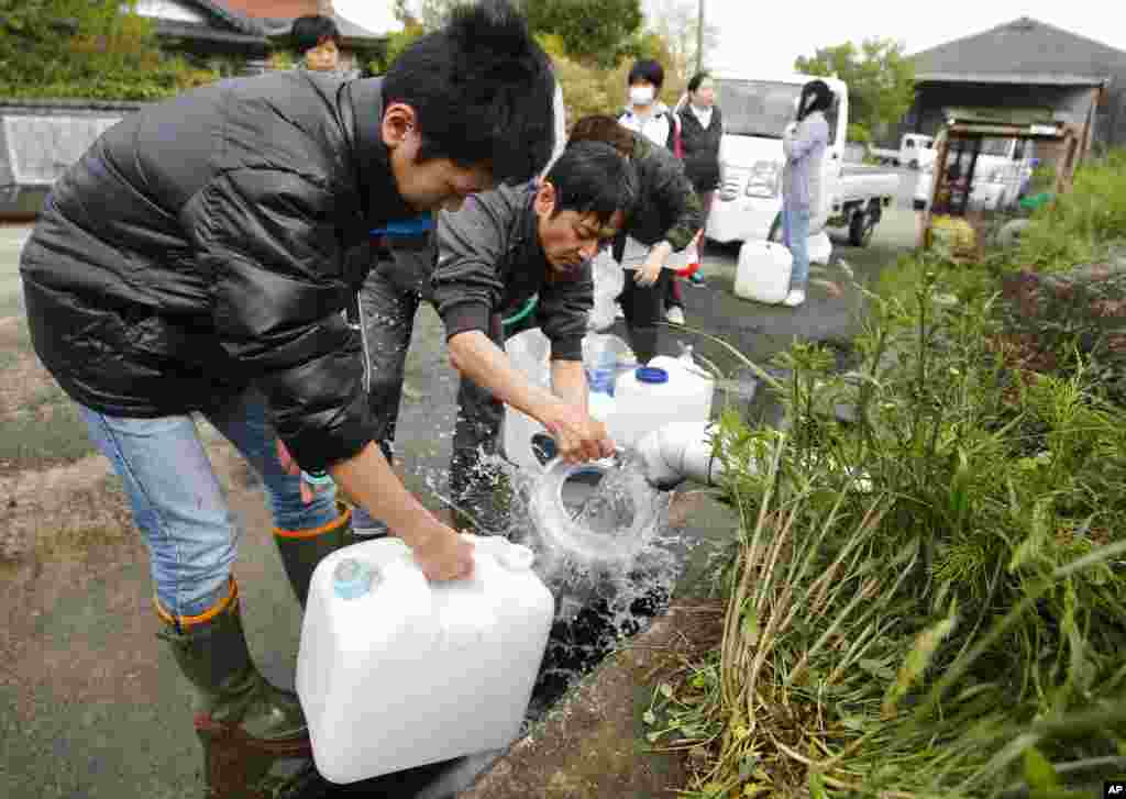 Evacuees collect spring water in plastic containers in Aso, Kumamoto prefecture, April 17, 2016.