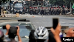 FILE - Police stand on a road during an anti-coup protest in Mandalay, Myanmar, March 3, 2021.