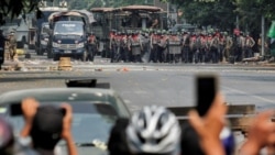 FILE - Police stand on a road during an anti-coup protest in Mandalay, Myanmar, March 3, 2021.