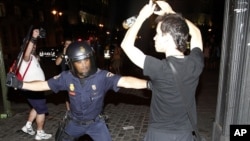 Policemen scuffle with protesters during a demonstration against what they claim is the expensive cost of the papal visit in central Madrid coinciding with the second day of the World Youth Day meeting, August 18, 2011