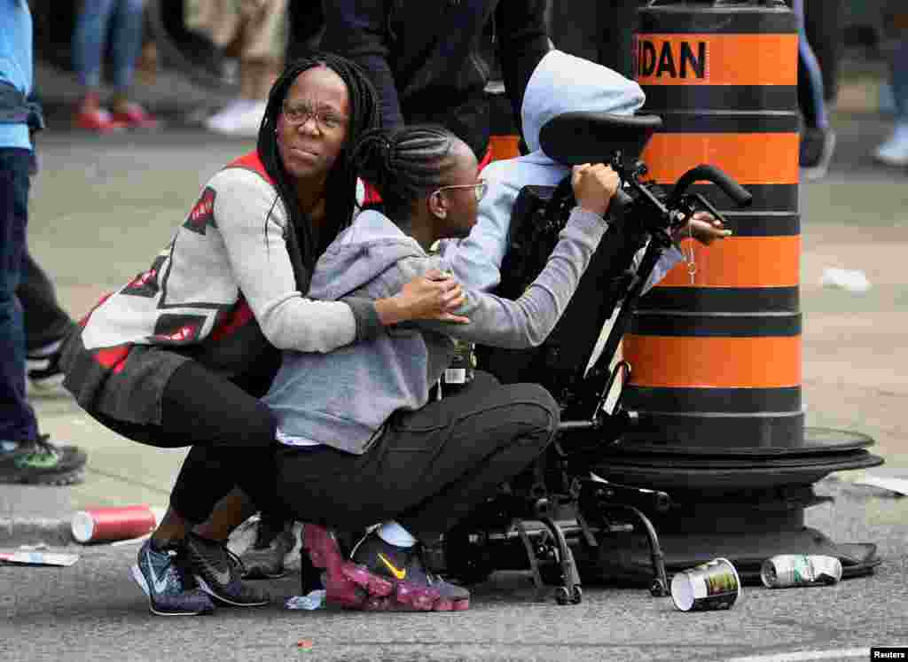 People take cover after reports of shots fired in the area where crowds gathered in Nathan Phillips Square to celebrate the Toronto Raptors victory parade in Toronto, Ontario, Canada, June 17, 2019.