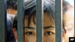 Family members of prisoners wait for their release in front of the Insein Prison gate in Rangoon, Burma, May 17, 2011.