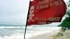 Bendera peringatan berkibar saat gelombang tinggi mencapai pantai sebagai ilustrasi. BMKG BMKG) mengeluarkan peringatan dini potensi lahirnya siklon tropis di sekitar Samudera Hindia, Barat Daya Lampung. (Foto: AFP/Sonny Tumbelaka)