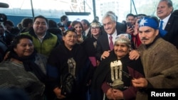 Chile's President Sebastian Pinera poses along with Mapuche indigenous community members during an official ceremony in Temuco, Chile, Sept. 24, 2018. 