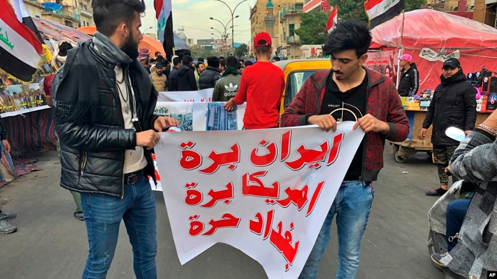 Người biểu tình giăng biểu ngữ viết "Iran, Mỹ hãy ra khỏi Iraq. Baghdad tự do" trong một buổi tọa kháng tại quảng trường Tahrir ở Baghdad, Iraq hôm thứ Tư 8/1/2020. (AP Photo/Qassim Abdul-Zahra)