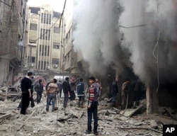 FILE - Syrians try to extinguish a fire that was caused by what they called a Syrian government aerial bombardment on the Damascus suburb of Douma, Syria.