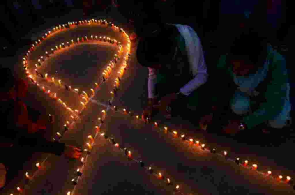 Personas en Nepal encienden velas en la forma de la cinta roja, símbolo universal de la conciencia y el apoyo a las personas que viven con el VIH.