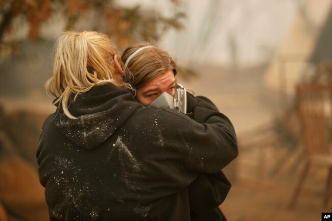 Krystin Harvey, left, comforts her daughter Araya Cipollini at the remains of their home burned in the Camp Fire, Nov. 10, 2018, in Paradise, Calif.