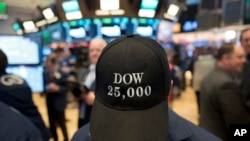 A stock trader wears a Dow 25,000 hat at the New York Stock Exchange, Jan. 4, 2018. 