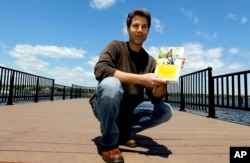 FILE - David Goldman poses with his book "A Father's Love" in Red Bank, N.J., May 5, 2011. Goldman became the poster dad for the issue of international child abductions when his ex-wife ran off with his son, Sean, to Brazil. He finally got custody of his son in 2009.