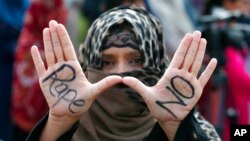 FILE - A woman flashes a "Rape No" sign, in Islamabad, Pakistan, Sept. 11, 2020.