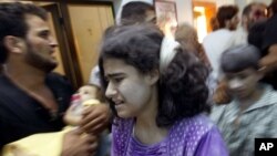 Người Syria bị thương đến một bệnh viện dã chiến sau vụ không kích vào nhà cửa của họ ở vùng ngoại ô Aleppo, ngày 15/8/2012