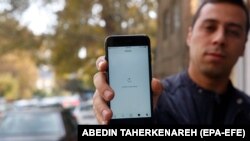 An Iranian man shows his phone while unable to load a social media page as internet service is reportedly disrupted, Tehran, Iran, 17 November 2019.