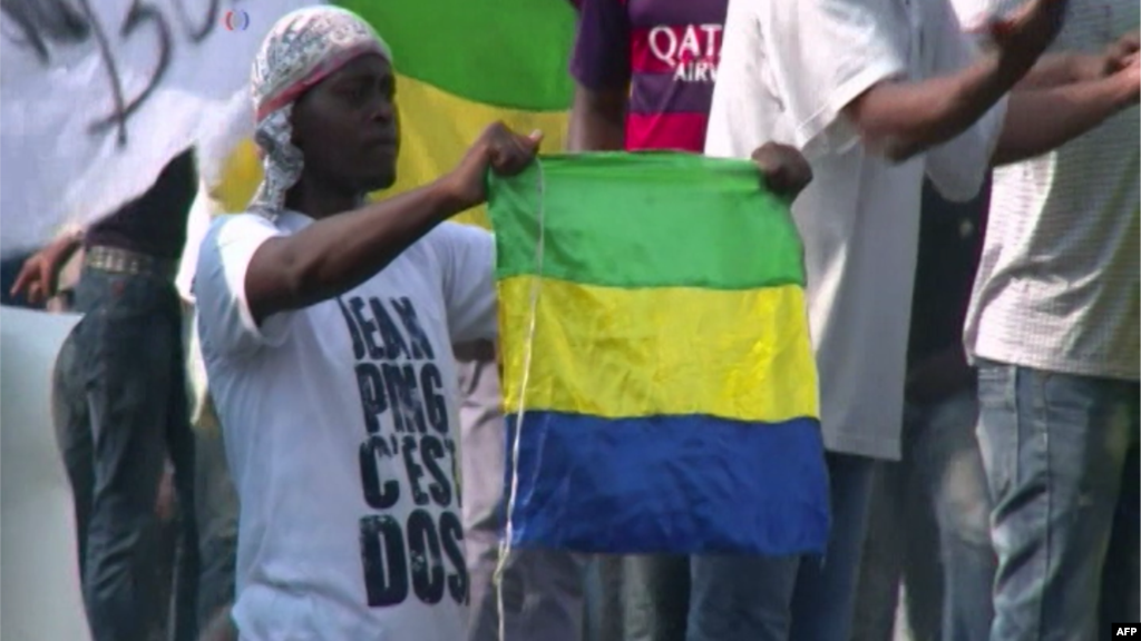 Un manifestant brandit le drapeau du Gabon lors des émeutes qui ont éclaté après l&#39;annonce officielle de la réélection du président sortant du Gabon, Ali Bongo Ondimba à Libreville,&nbsp;le 30 août 2016.