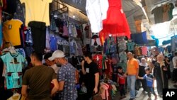 Warga membeli pakaian dalam persiapan hari raya Idulfitri, di pasar Syorjah, Baghdad tengah, Irak, Selasa, 11 Mei 2021. (AP Photo / Hadi Mizban )