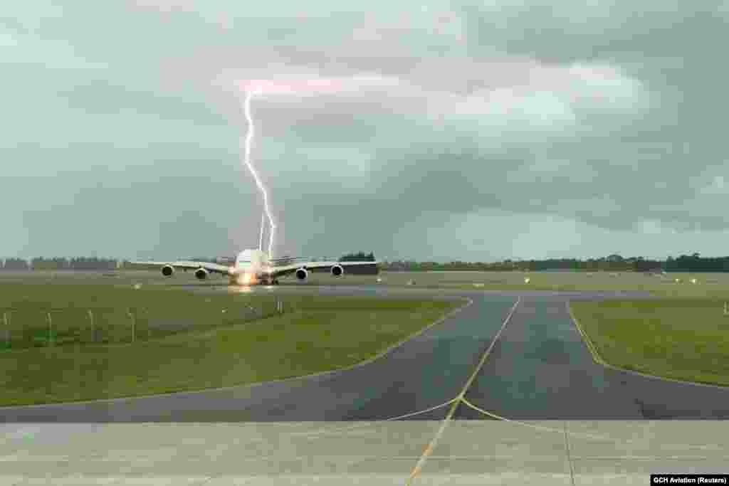 A lightning strikes near an Emirates A380 plane at Christchurch Airport, New Zealand in this still image obtained from a social media video.