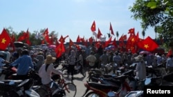 Workers wave Vietnamese national flags during an anti-China protest at a Chinese-owned shoe factory in Vietnam's northern Thai Binh province May 14, 2014. 