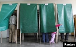 FILE - A child gestures during 2012 municipal elections in Valparaiso, Chile. The country reportedly works hard to enfranchise voters.