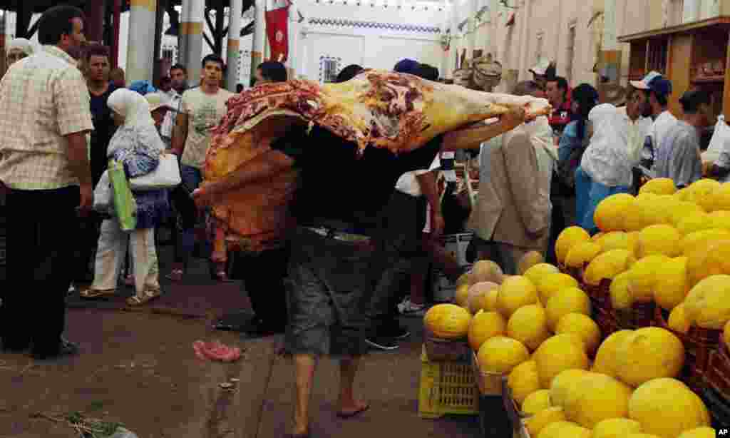 A butcher carries meat on the first day of Ramadan in downtown Tunisia August 1, 2011. Muslims around the world abstain from eating, drinking and conducting sexual relations from sunrise to sunset during Ramadan, the holiest month in the Islamic calendar.